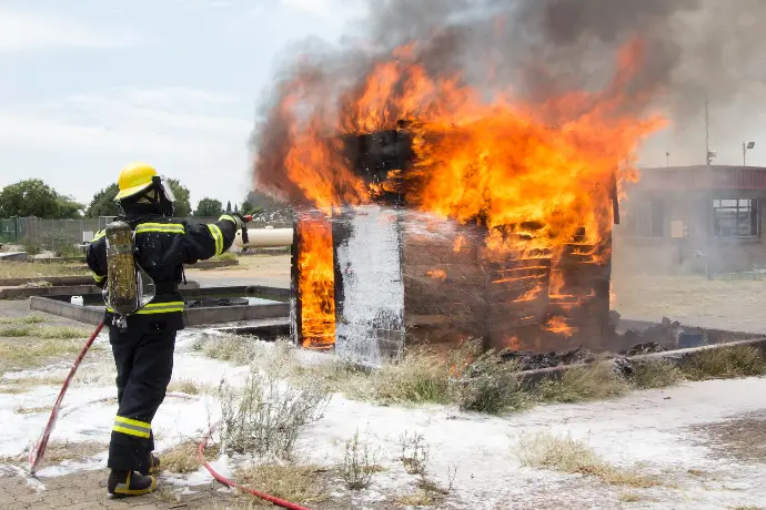 man in black jacket and black pants standing near burning fire